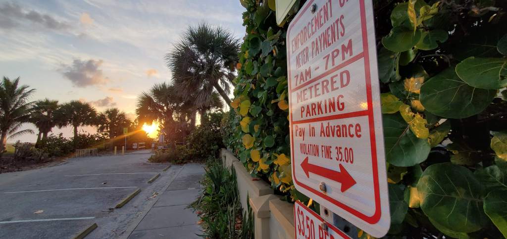 Sign at a beach access point letting you know this is paid parking and it is enforced