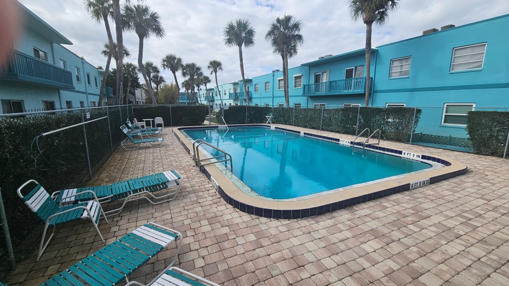Community pool at Ocean Park South. Paver pool deck and lounge chairs