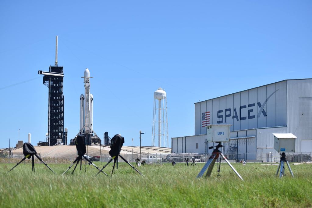 SpaceX Falcon heavy rocket on the launch pad. In the foreground are the press photographers cameras.