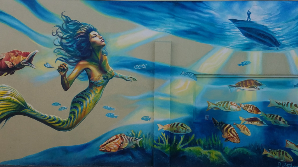older murals in cocoa beach. Mermaid with fish and a boat