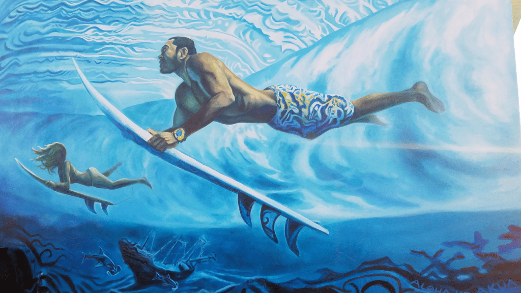 surfers diving under a wave