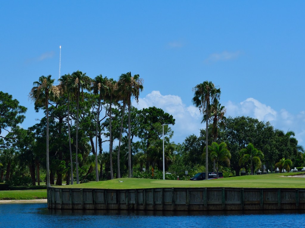 Iconic green near entrance of the community with a rocket launch happening